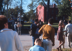 Actor Kyle Johnson (Newt Winger), facing away from the camera, is photographed byGordon Parks' oldest son, Gordon Parks Junior. Various actors and crew members mingle in the street in front of a red brick house.