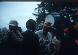 Actor Kyle Johnson (Newt Winger) dressed in a black suit, in conversation with production crew. The photograph was likely taken around the filming of Sarah Winger‚Äôs funeral scene.