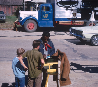 Director Gordon Parks signing autographs for young fans in front of production equipment.