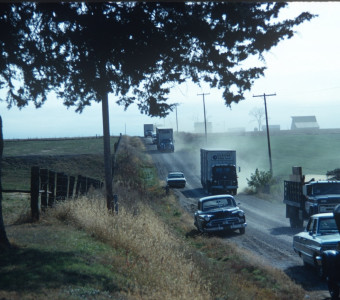 Cars and trucks with production equipment on dirt road outside of Fort Scott, Kansas near location of Winger House.