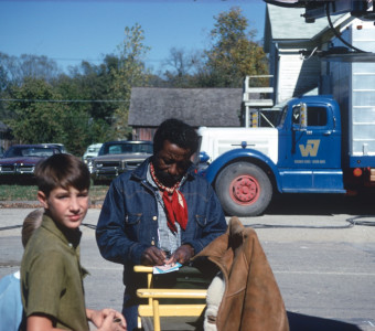 Director Gordon Parks, autographing a book for two young boys.