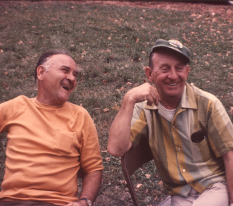Two crew members laughing while seated.