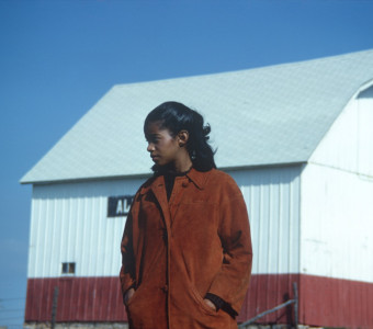 Actress S. Pearl Sharpe (Prissy) in front of a red and white barn.