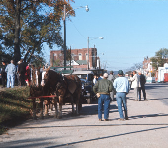 Horse and wagon, cast, and crew at side of road in downtown Fort Scott, Kansas.