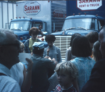 Cast, Crew, and others in front of production vehicles.