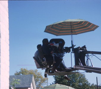 Director Gordon Parks giving direction in megaphone while filming from above.