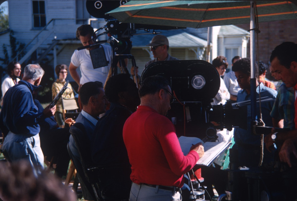 Production crew preparing for filming.Director Gordon Parks is seated in the center behind the camera.