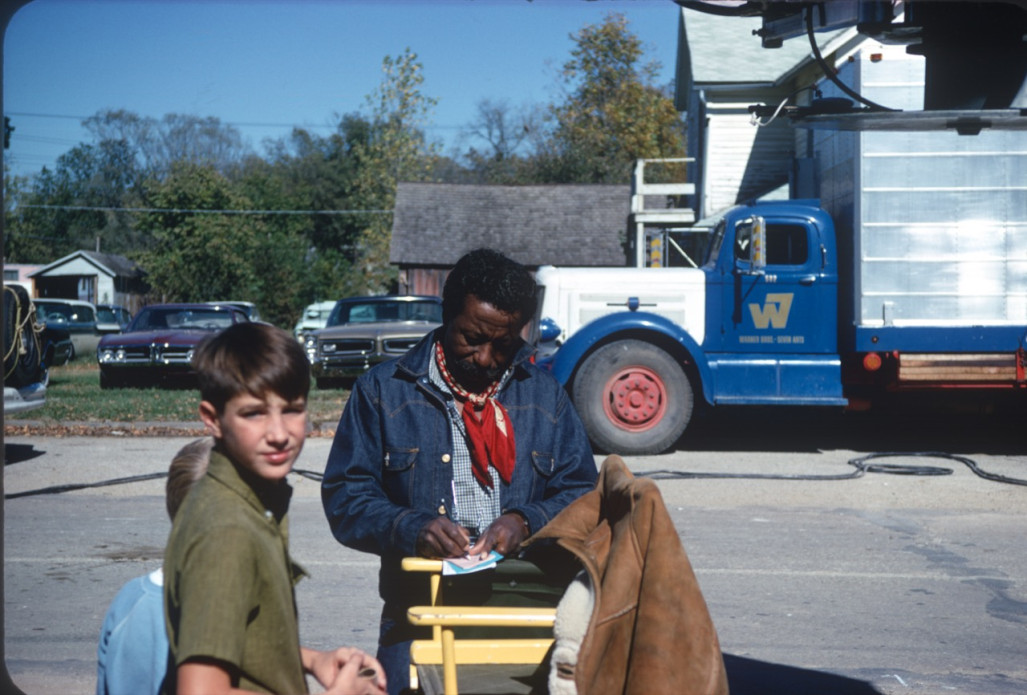 Director Gordon Parks, autographing a book for two young boys.