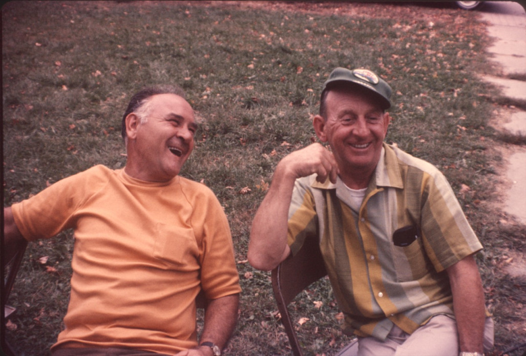 Two crew members laughing while seated.