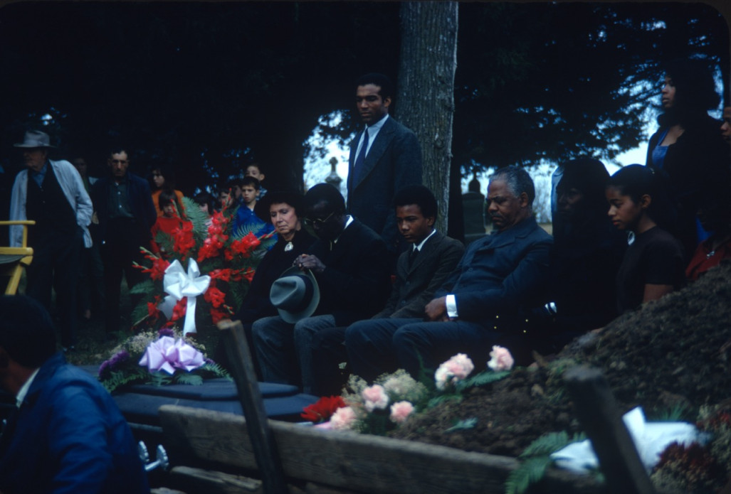 Actors Hope Summers (Mrs. Kiner), Joel Flullen (Uncle Rob), Phillip Roye (Pete Winger), Felix Nelson (Jack Winger), S. Pearl Sharpe (Prissy), and other actors, crew, and observers, during the filming of Sarah Winger‚Äôs funeral scene.