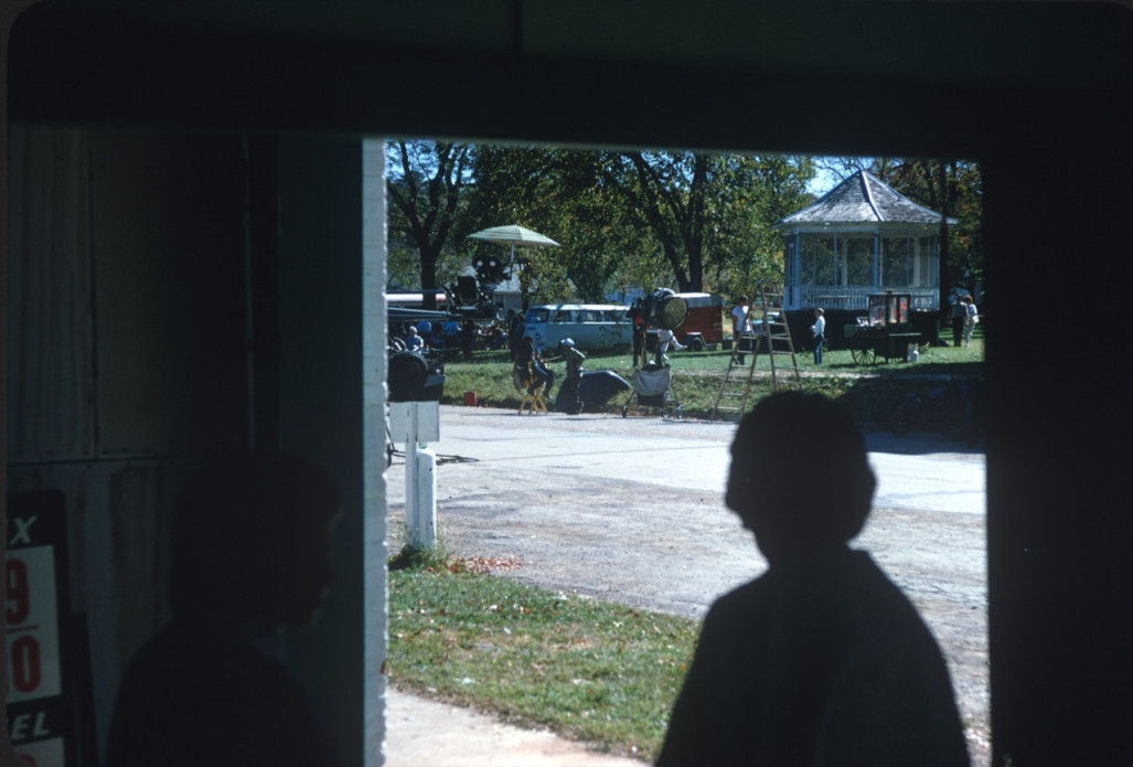 Silouette of a woman in a doorway looking out on the production crew preparing to film in a local park located in Fort Scott, Kansas.