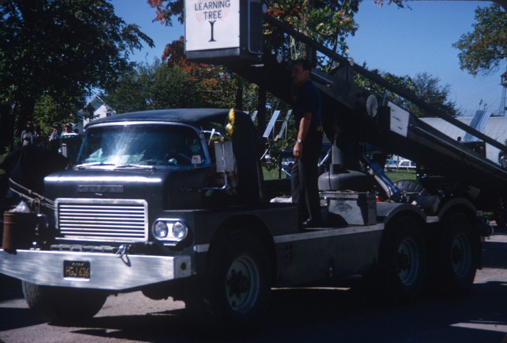 Crew member and truck with film production equipment.