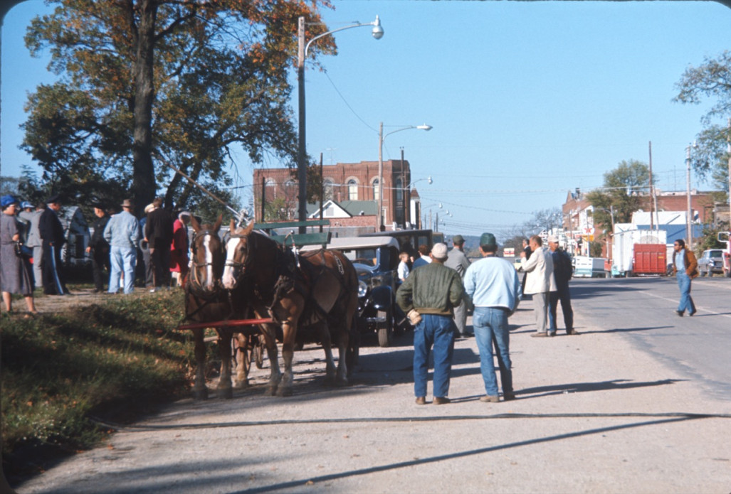 Horse and wagon, cast, and crew at side of road in downtown Fort Scott, Kansas.