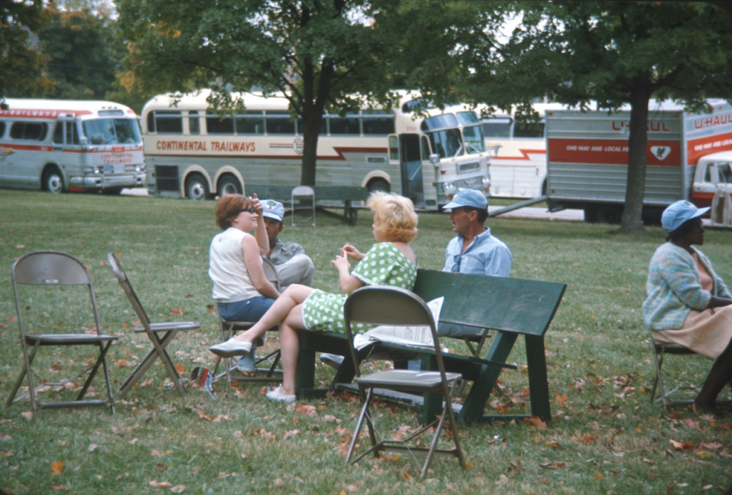 Actors and crew seated in front of production vehicles wearing Learning Tree hats.