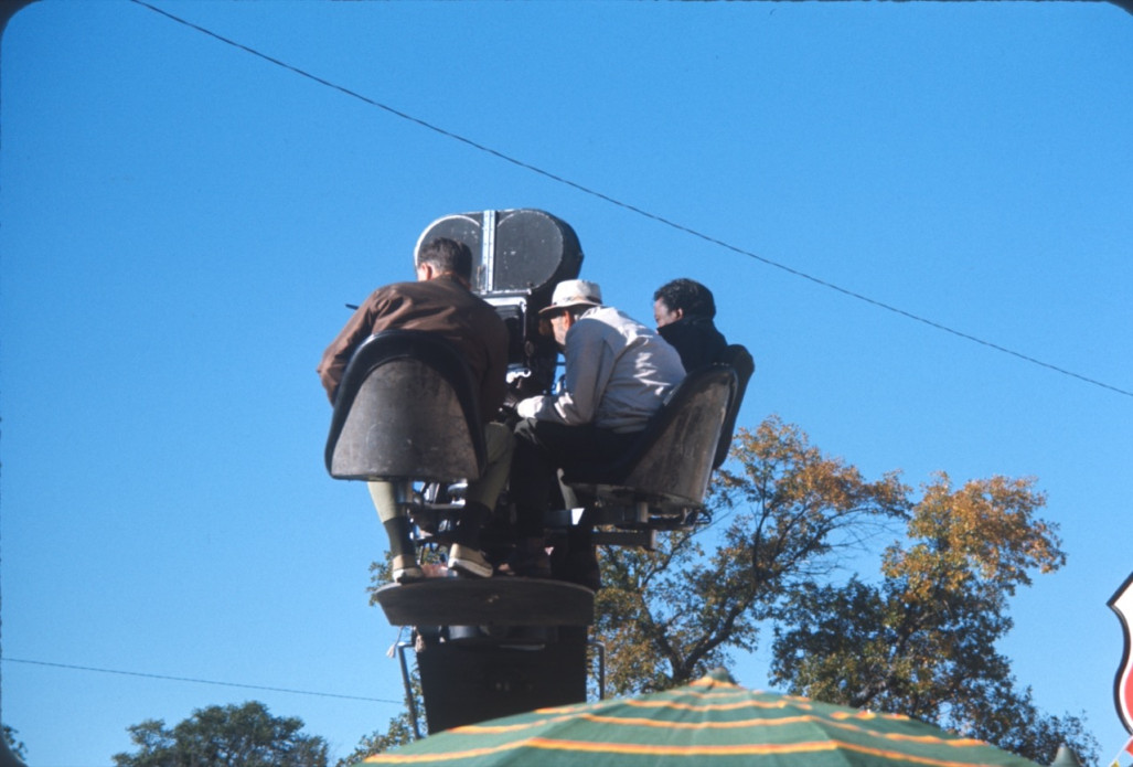 Director Gordon Parks, right, and two production crew members filming from above by the Phillips 66 gas station.