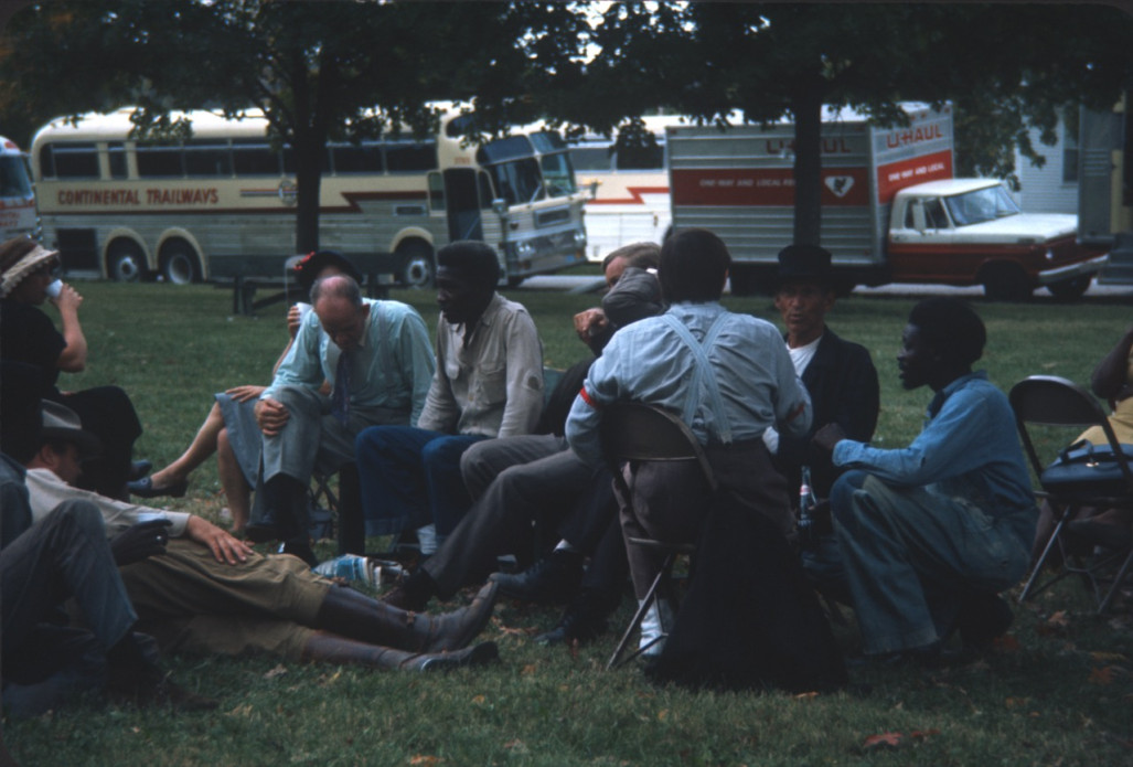 Cast and crew members, including Dana Elcar (Kirky), on ground, Don Dubbins (Harley Davis) with elbow up, and malcolm attebury (Silas Newhall0 in black hat sitting taking a break on a lawn in front of production buses.